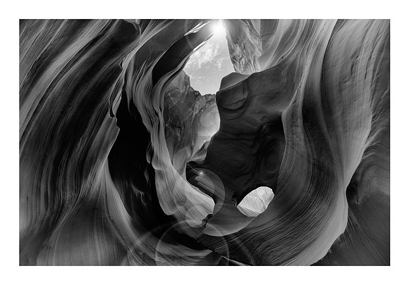 Black and White looking up 50 feet into the sun from the floor of Antelope Canyon