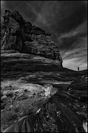 Black and White of man set against huge Lake Powell rock